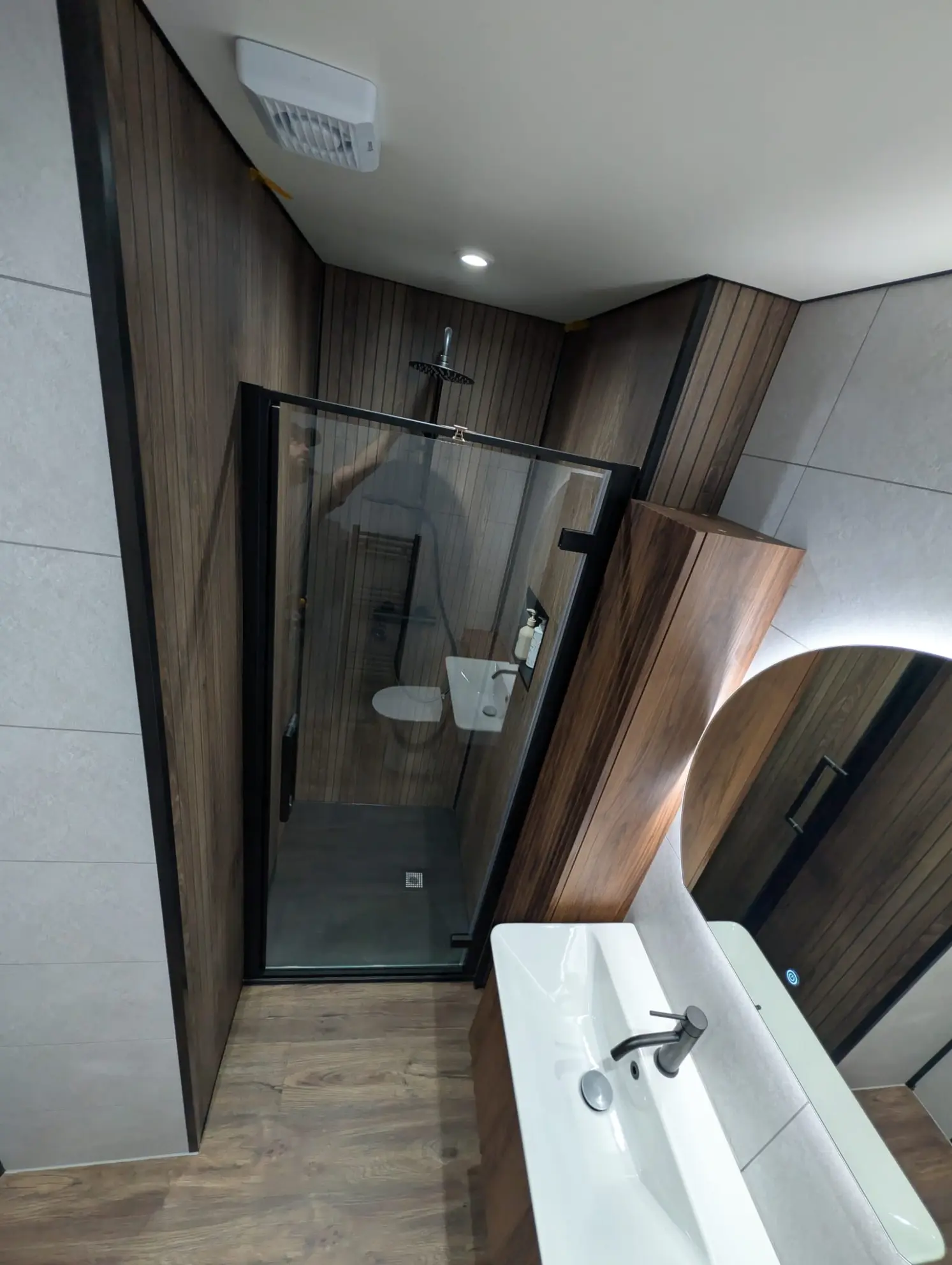 Black framed glass shower enclosure with walnut ribbed wet wall panels and rainfall shower in Leith en-suite