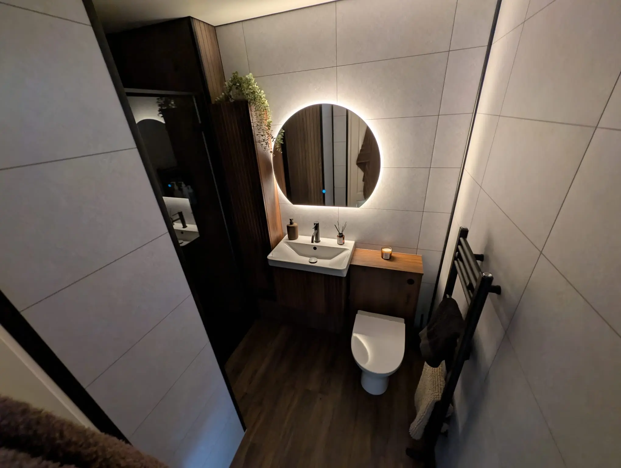 Wall-hung WC with walnut vanity, round LED mirror and ambient lighting in Leith en-suite