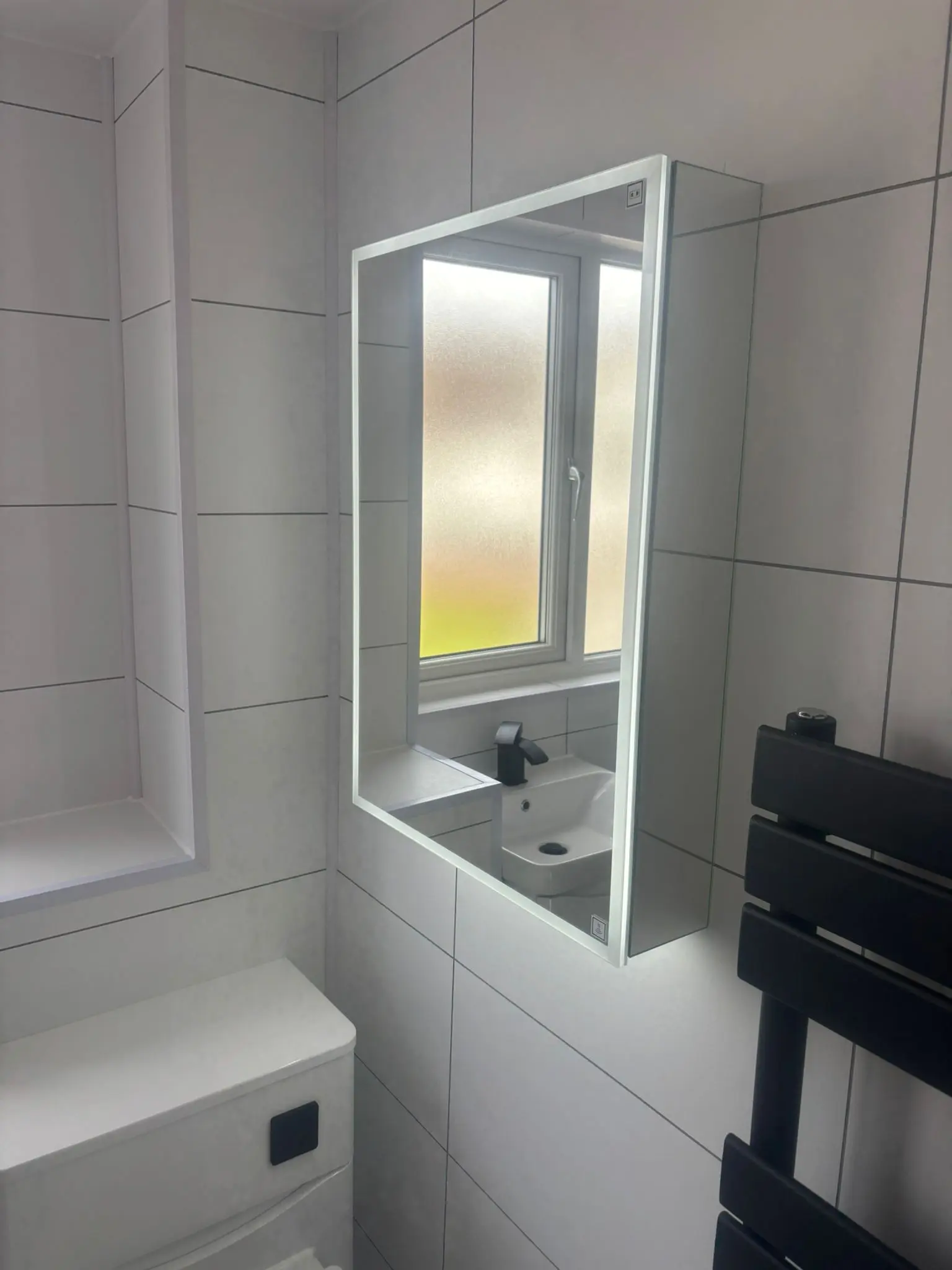 LED backlit mirror and anthracite towel rail in completed Portobello bathroom