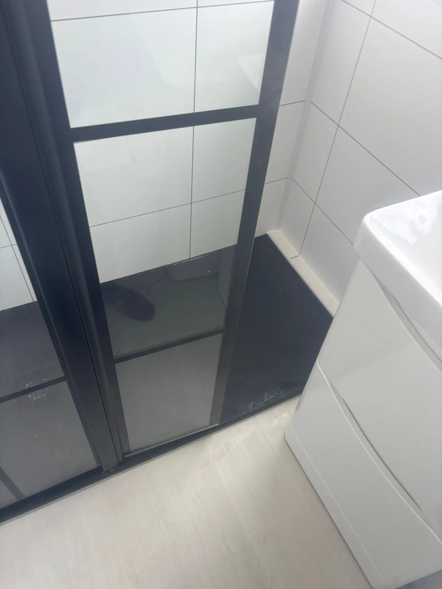 Crittall-style black shower screen detail with white wall tiles in Portobello bathroom