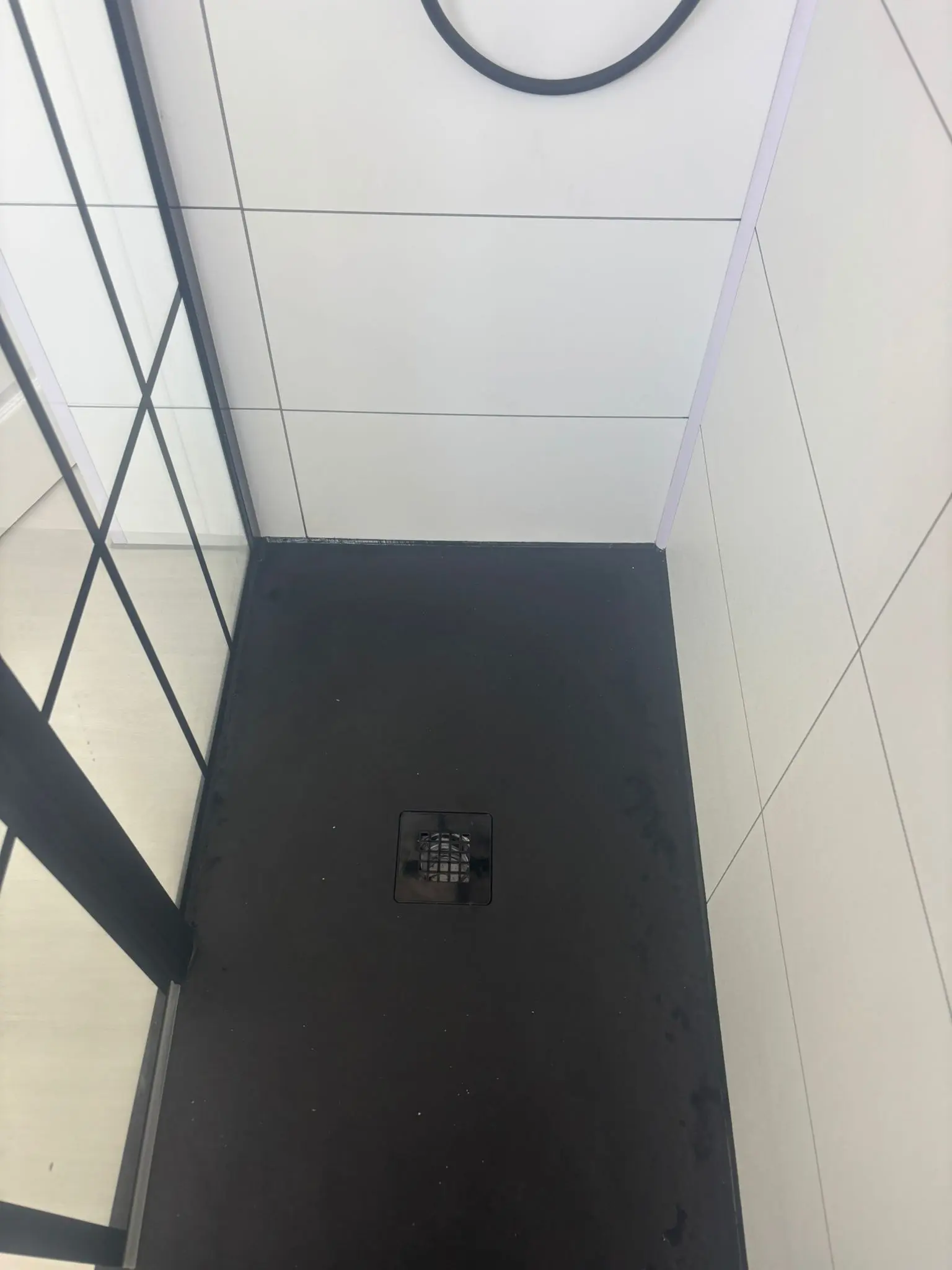 Black slate-effect shower tray with centre drain and Crittall screen in Portobello