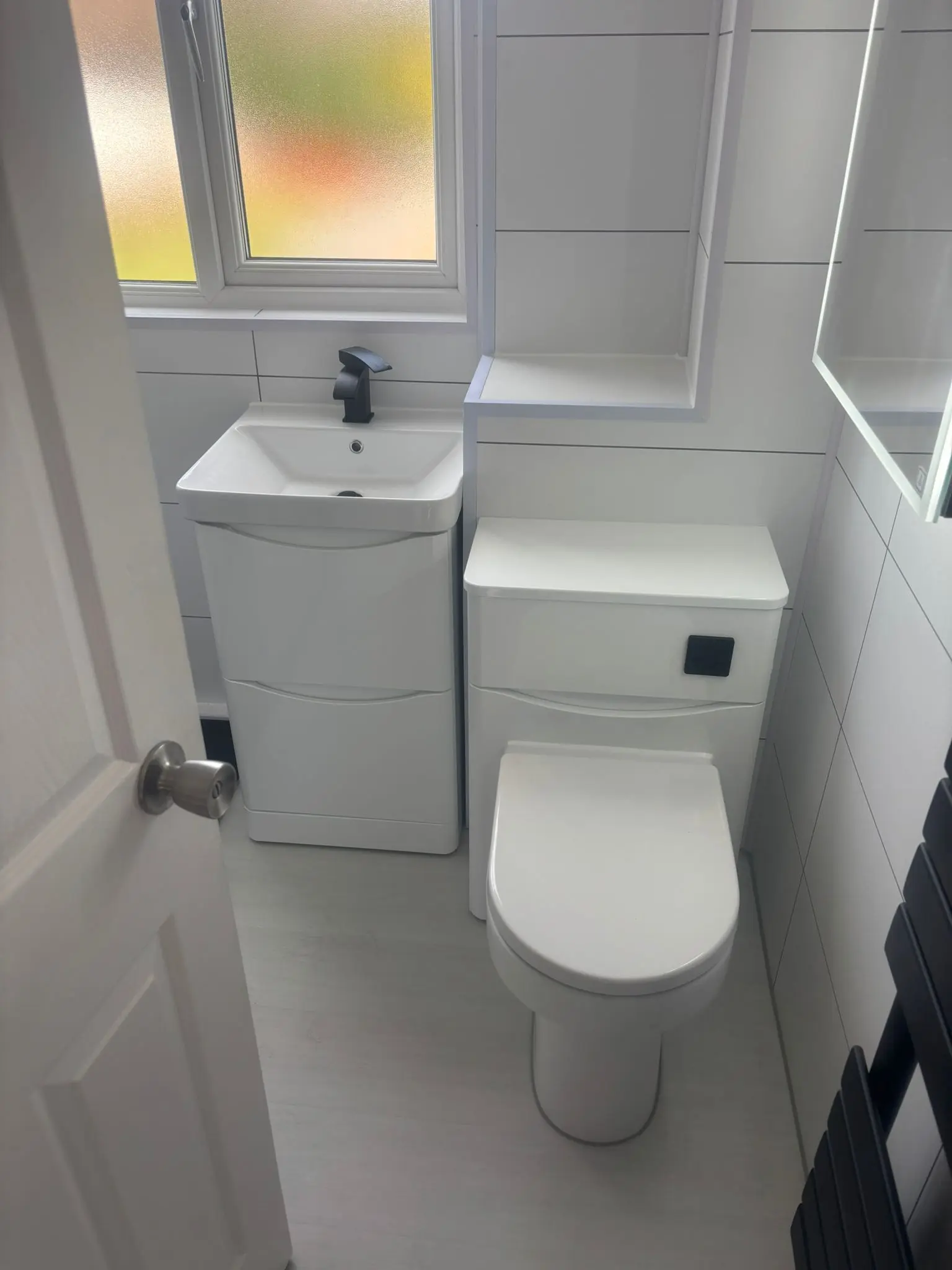 Curved vanity unit and WC with matte black accents in Portobello bathroom