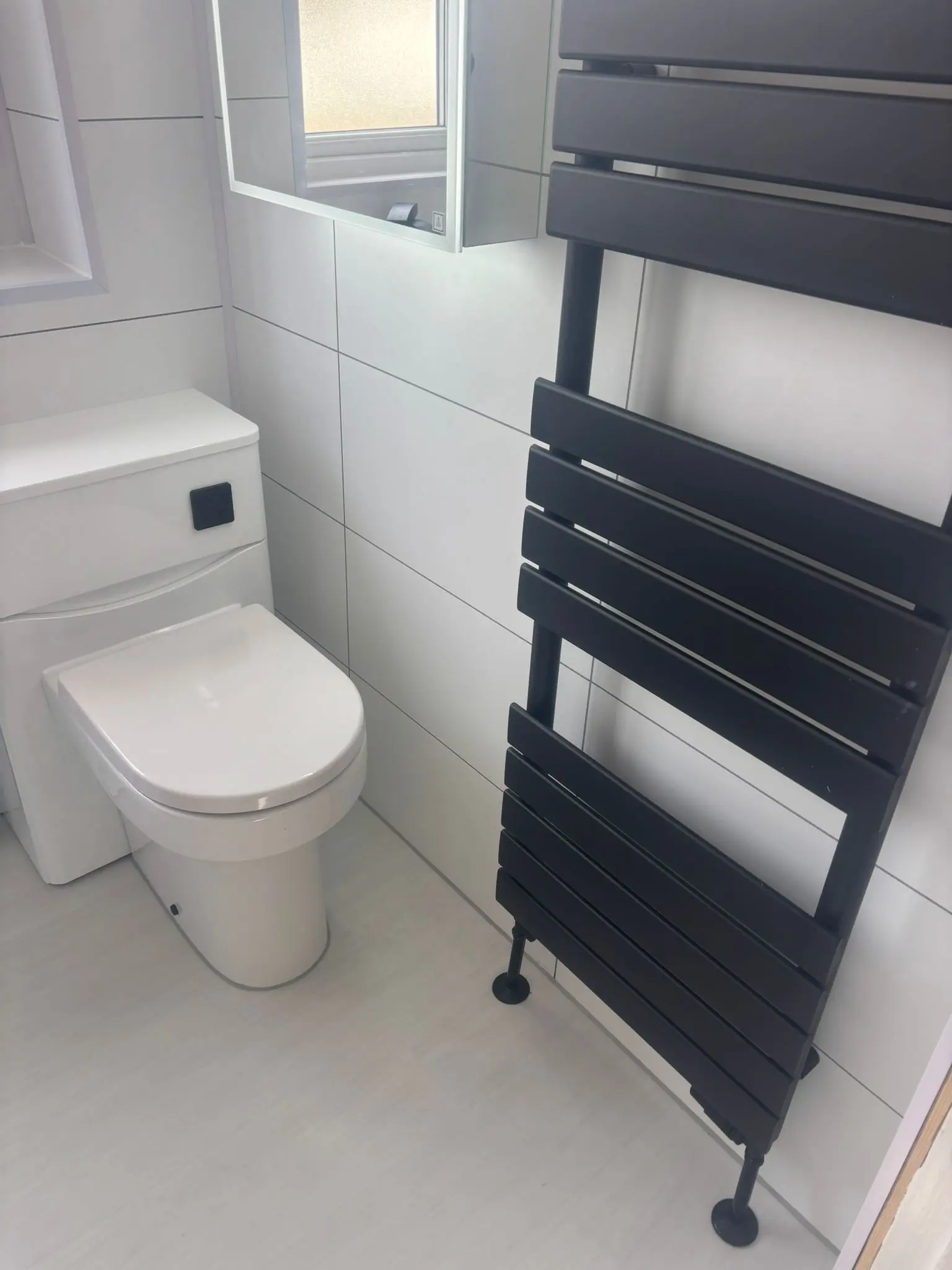 Modern WC with concealed cistern and anthracite flat panel towel rail in Portobello