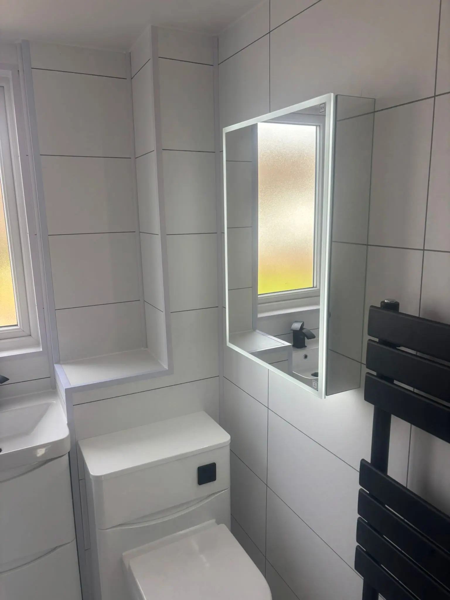 Wide angle view of completed Portobello bathroom showing LED mirror, vanity and towel rail