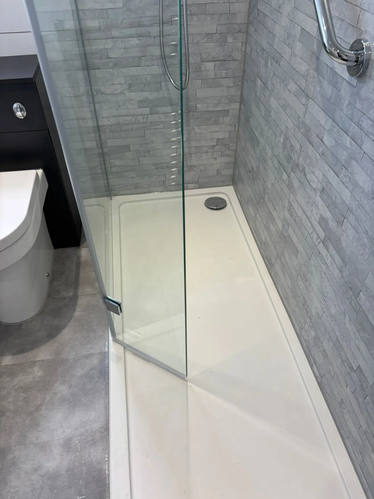 White low-profile shower tray with chrome waste and split-face stone tiles in Stockbridge walk-in shower