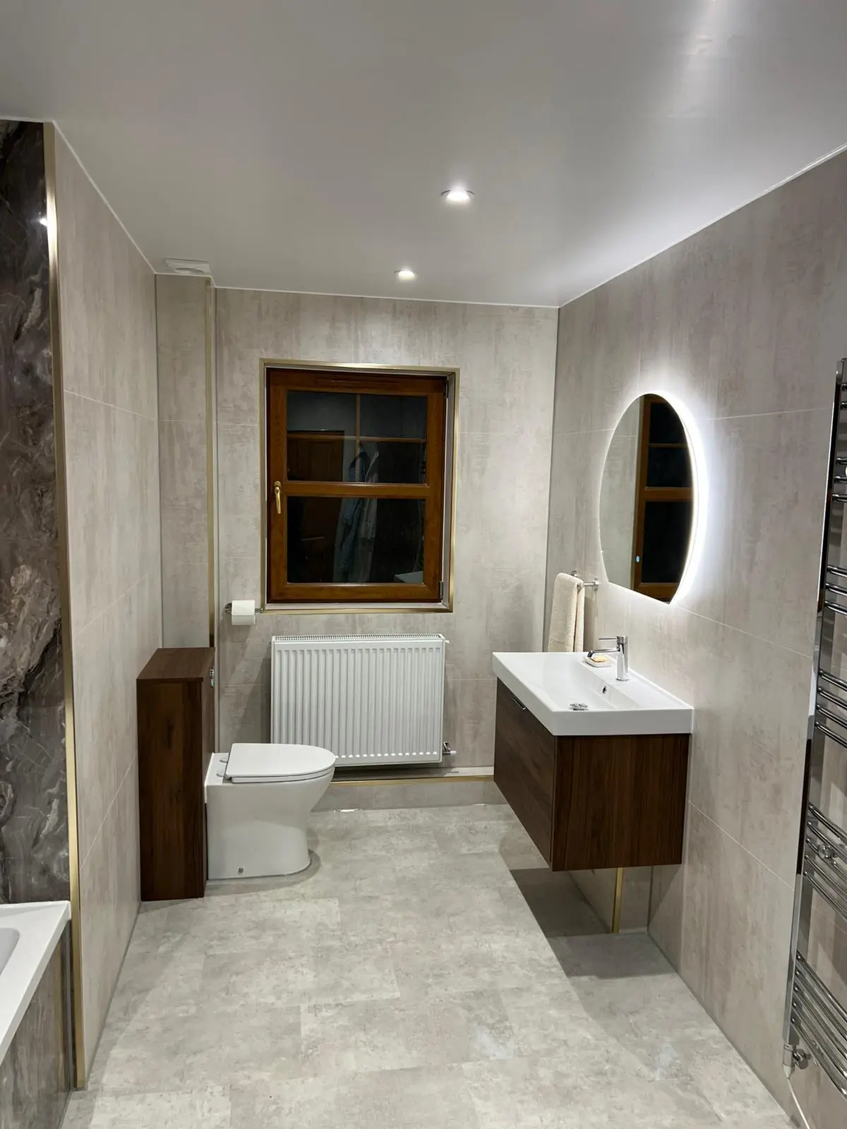 Complete bathroom with oval mirror and wood accents