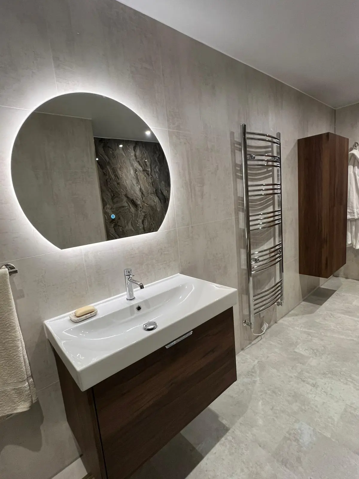LED backlit mirror with walnut vanity and chrome towel rail