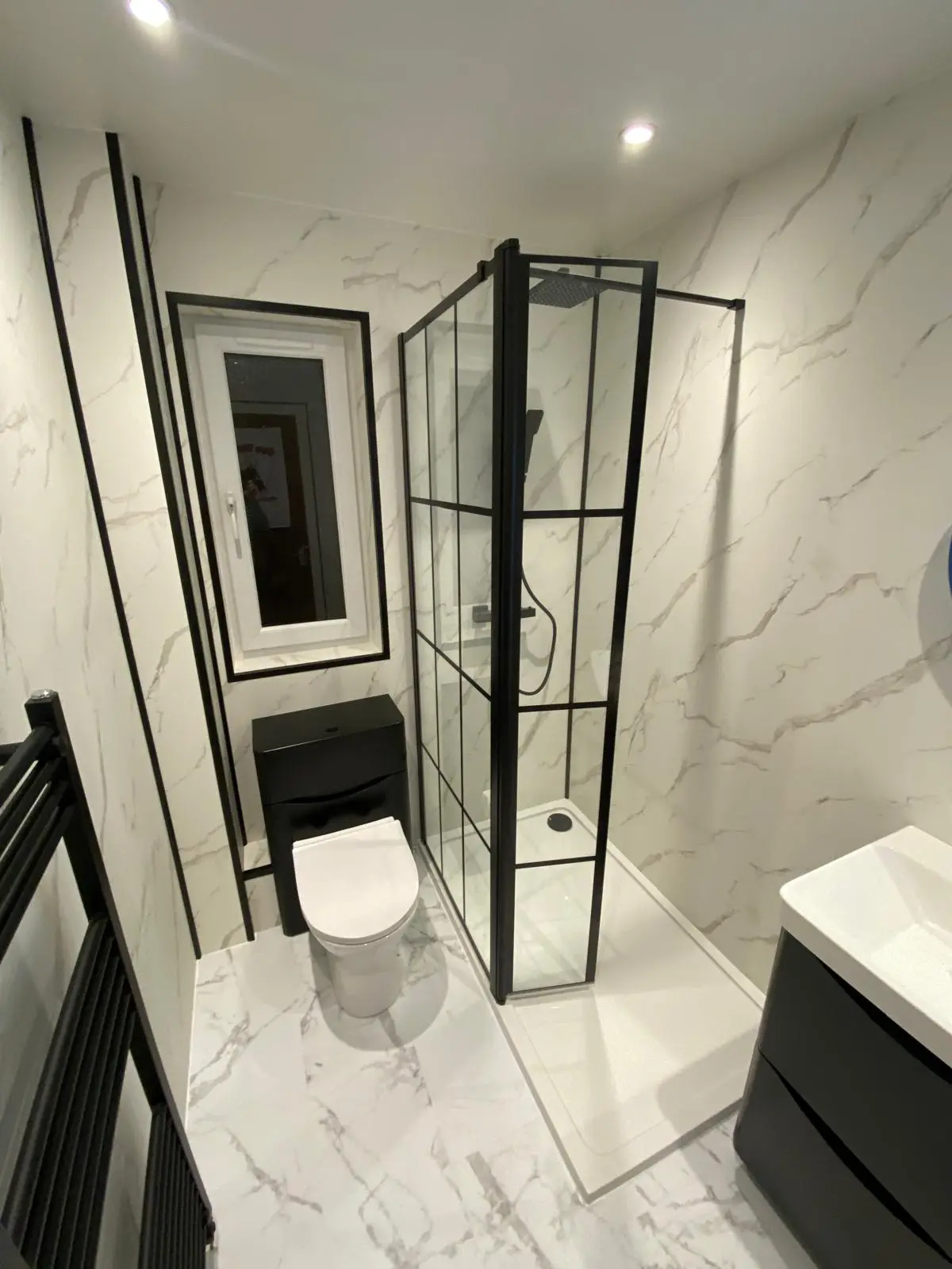 Black and white marble effect bathroom with Crittall shower screen